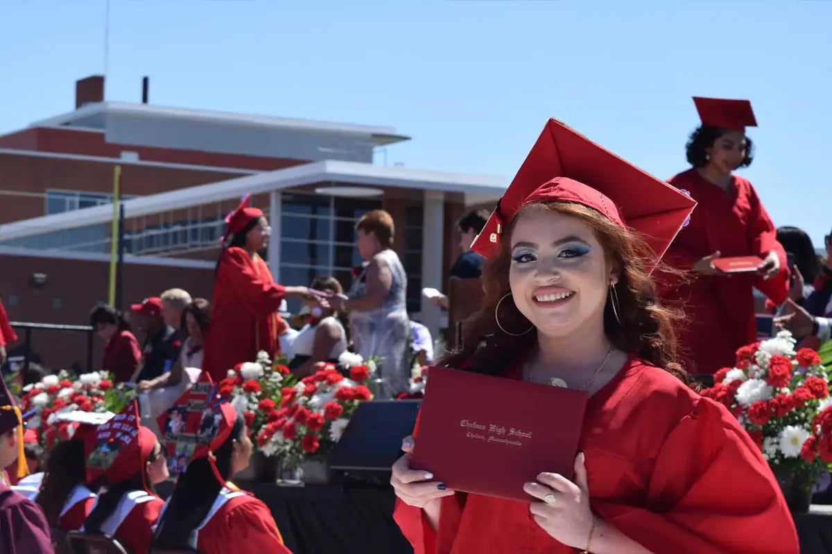 Young woman in cap and gown smiling at graduation ceremony