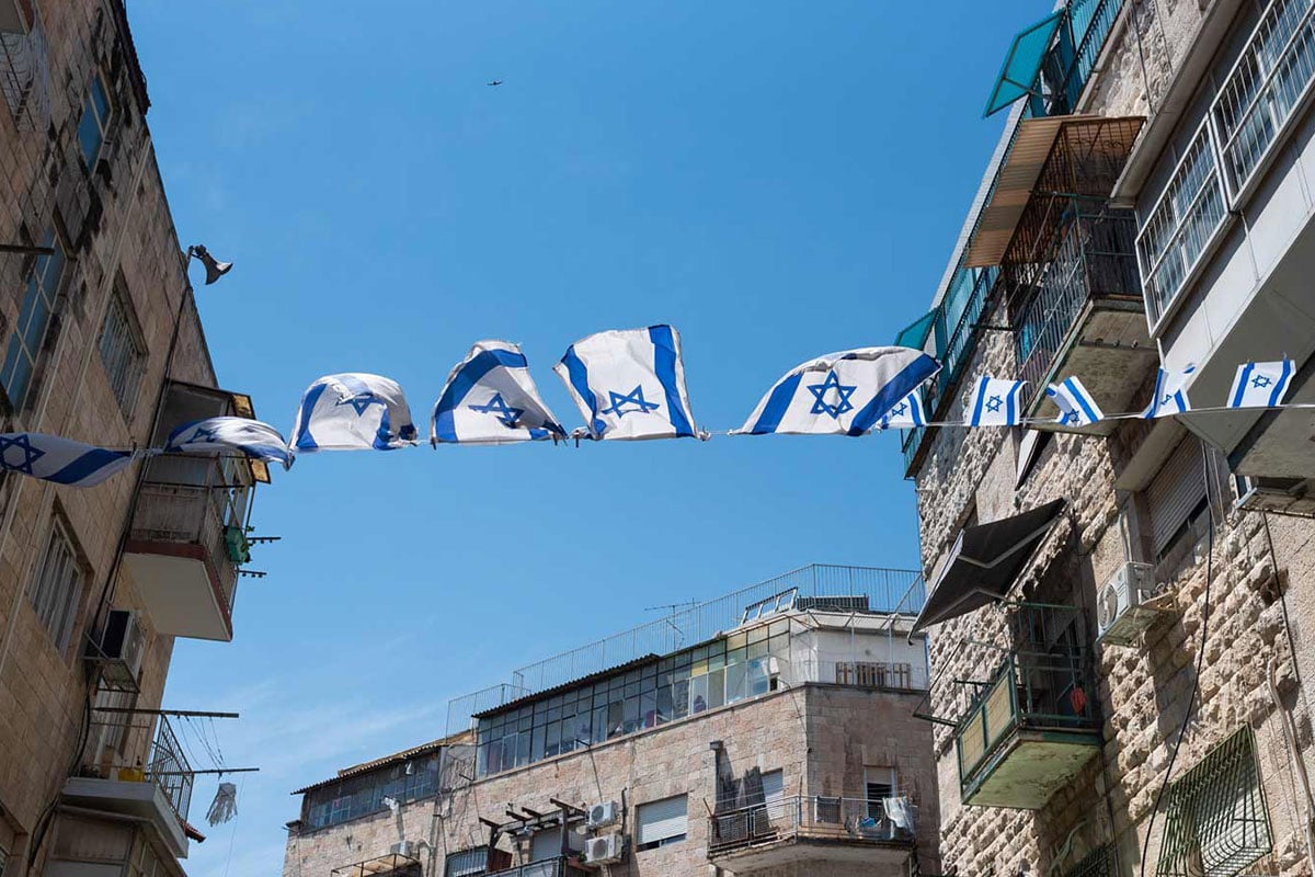 Row of Israeli flags displayed outdoors, symbolizing the connection to Israel and global Jewish life supported by Combined Jewish Philanthropies in Boston.