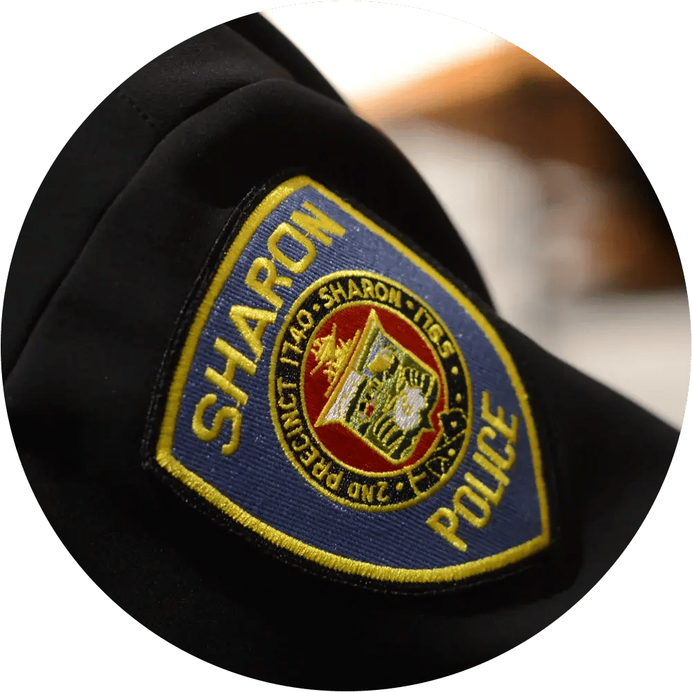 Close-up of a police badge on an officer’s uniform.