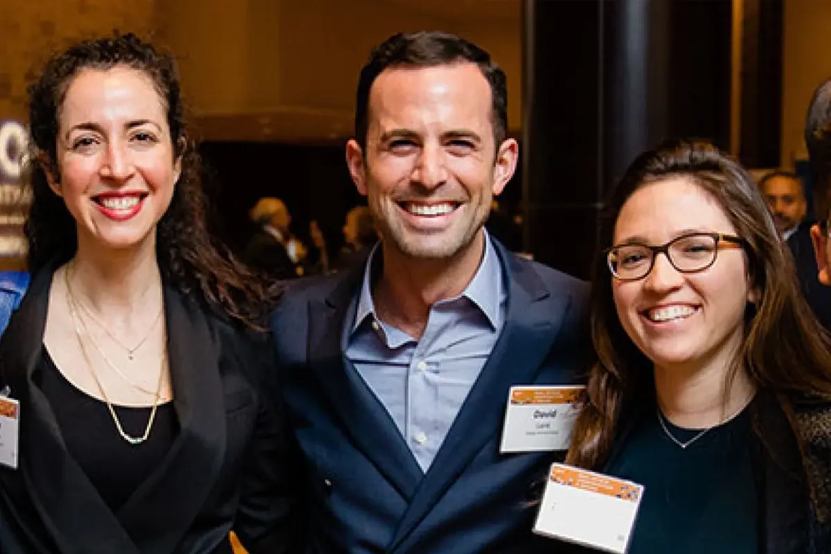 Jewish professional networks boston: Three professionals smile together during a Jewish business networking and community leadership event.