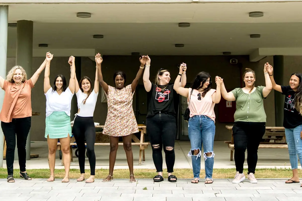 Women and girls standing arm in arm together