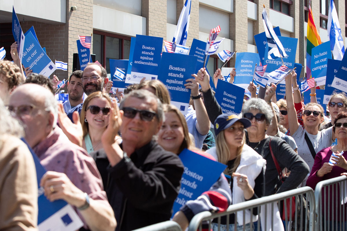 Jewish Community Safety Boston community rally with participants holding signs that read 