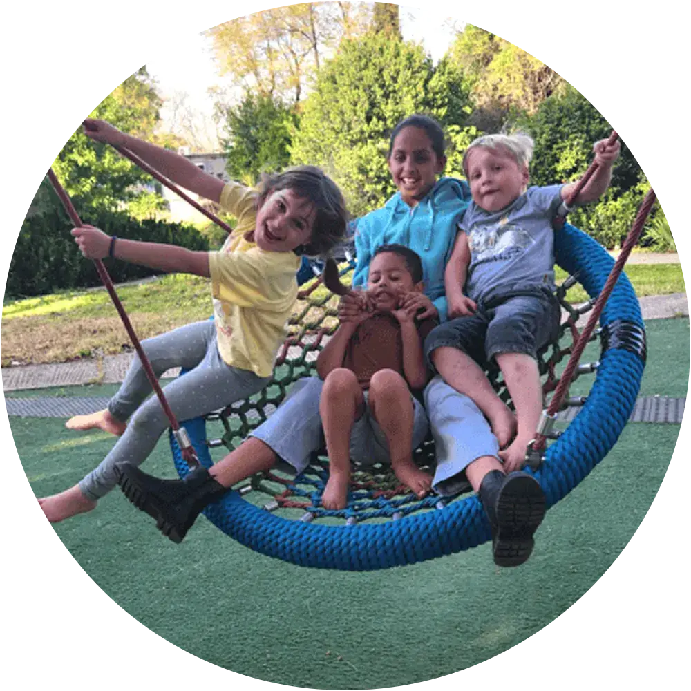 Children playing on a swing set in a community in northern Israel.